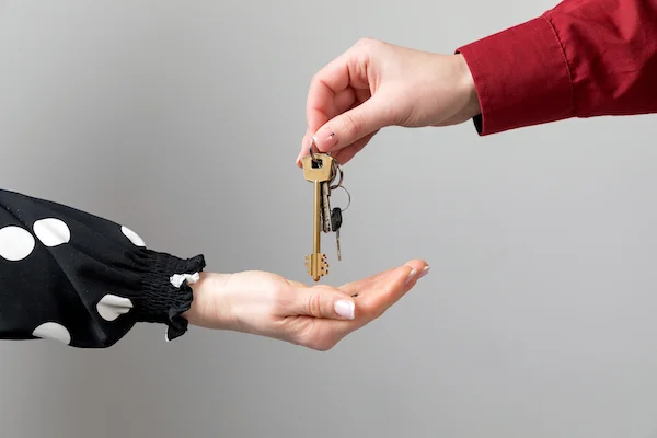 Faire confiance à des home sitters : un homme remettant un trousseau de clés à une femme
